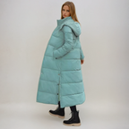 Lange gewatteerde jas met capuchon voor dames in turquoise